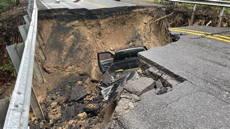 Truck falls into sinkhole opened by heavy storms .
